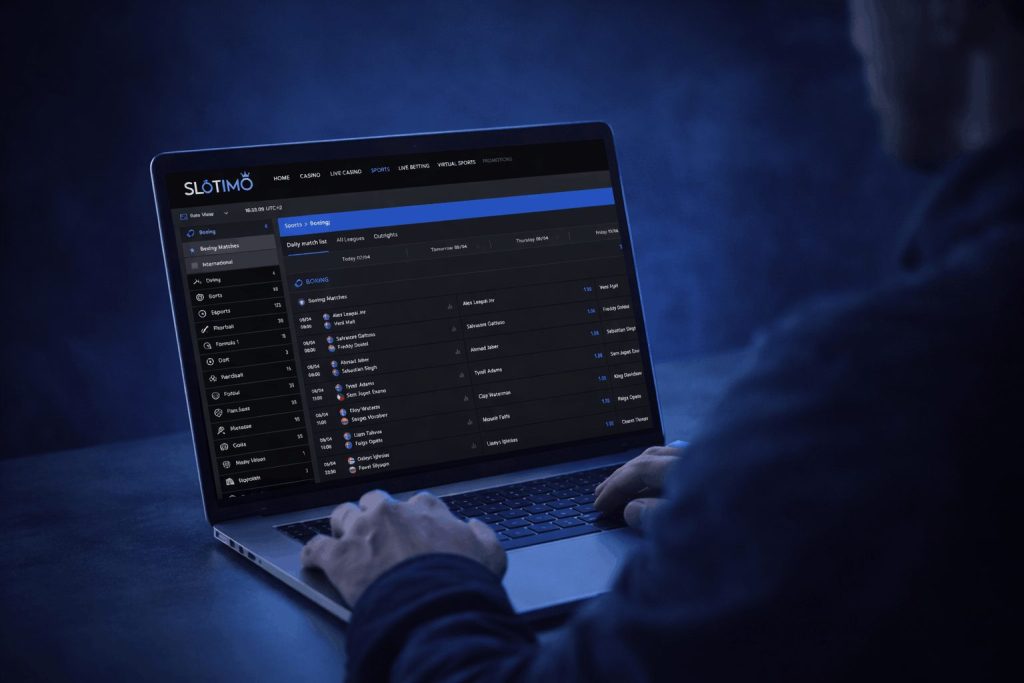 Man using a laptop with Slotimo sportsbook showing boxing betting odds