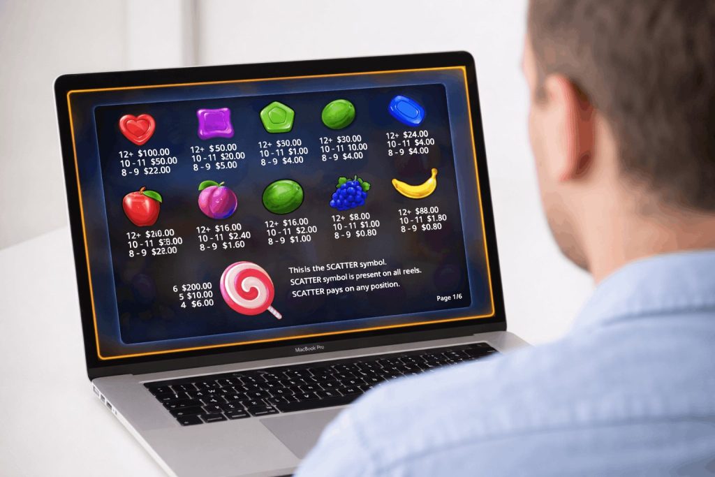 Man viewing cluster pays Sweet Bonanza slot paytable on a laptop screen