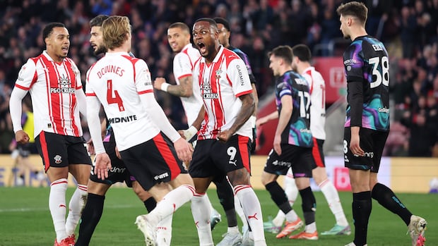 Cyle Larin celebrating a goal with Canadian teammates during a soccer match