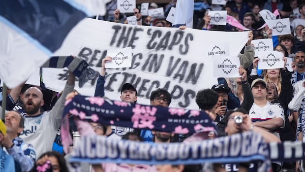 Vancouver Whitecaps fans hold up "Save the Caps" signs before MLS match against Sporting Kansas City