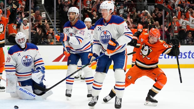 Oilers player celebrates goal while Ducks players look on during intense playoff hockey game