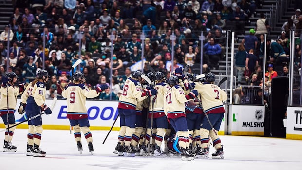 Montreal Victoire hockey players celebrate a first-round playoff victory at center ice