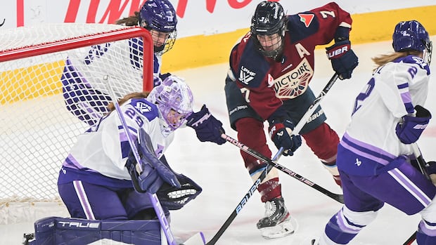 Four PWHL female hockey players on the ice competing in a game