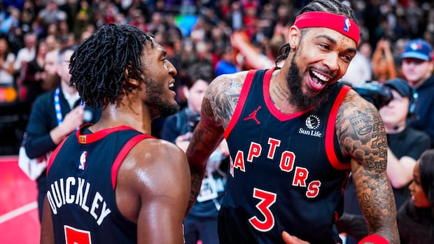 Toronto Raptors players celebrate a crucial basketball play during an intense NBA game