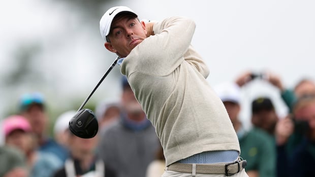 Golfer intently watching the trajectory of his shot on a sunny day during a Masters tournament