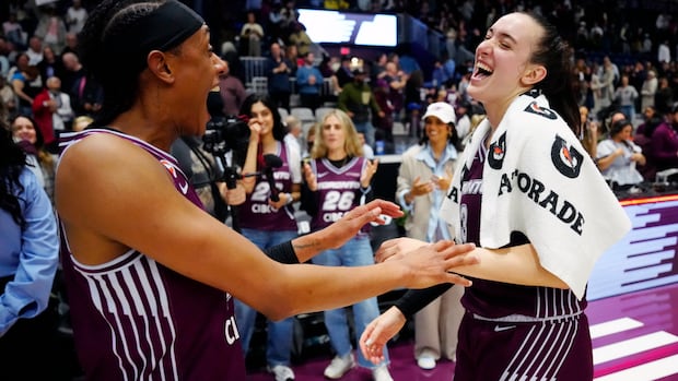 Two Toronto Tempo players celebrating on the court during their first-ever WNBA win