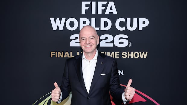 Man smiling and giving two thumbs up in front of FIFA World Cup 2026 Final Halftime Show backdrop