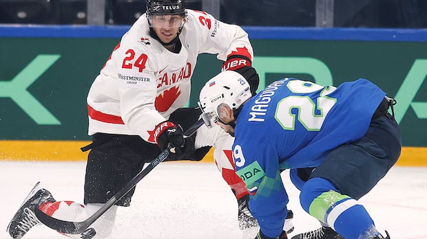 Canada forward Dylan Cozens attempts a close-range shot while Slovenia's Aleksandar Magovac tries to block during a 2026 world hockey championship game