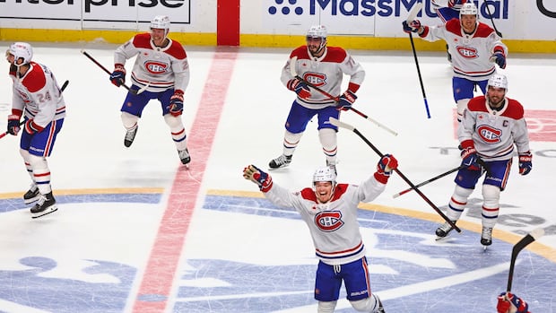Montreal Canadiens players celebrating on the ice after their overtime win against the Buffalo Sabres in Game 7