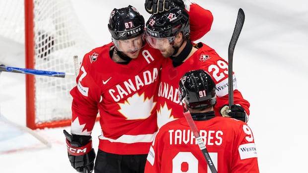 Three Canadian hockey players celebrate a goal together during their game against Denmark at the World Championship