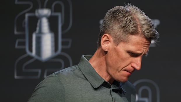 Edmonton Oilers head coach Kris Knoblauch stands near a Stanley Cup logo during a press conference