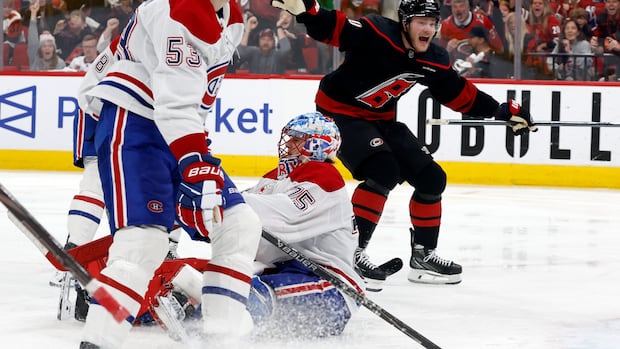 Montreal Canadiens and Carolina Hurricanes players compete intensely on the ice during overtime in Game 2