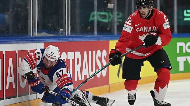 American forward and Canadian defenceman battle for puck during men's world hockey championship quarterfinals in Fribourg