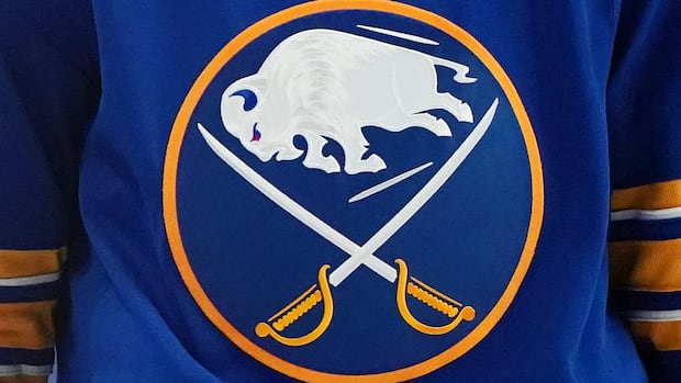 Buffalo Sabres hockey jersey hanging in arena symbolizing Gerry Meehan's legacy