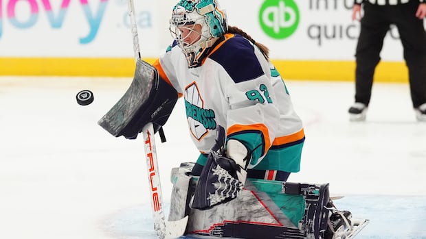 PWHL goaltender stretches to stop a puck during a tense game save attempt