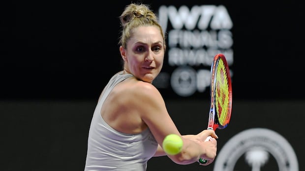 Canadian tennis player preparing to hit a backhand shot during women's doubles match at French Open