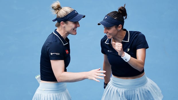 Canada's Dabrowski and partner Stefani celebrate winning their doubles opener at French Open on blue court